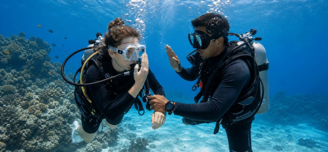 セブ島の海でインストラクターからダイビング講習を受ける旅行者