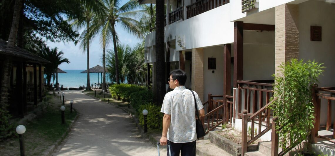 マクタン島のビーチ沿いホテルを見ながら歩く旅行者
