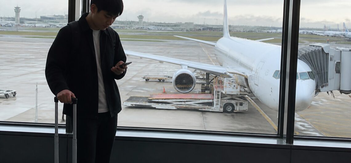 東京からセブ島行きの便を空港で確認する旅行者