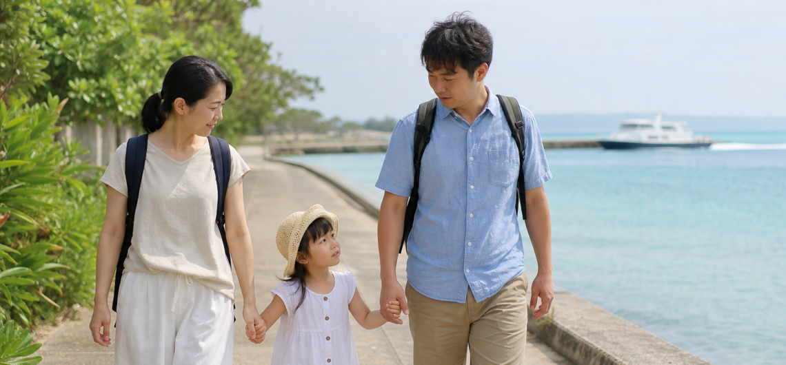 海辺の遊歩道を歩く親子三人